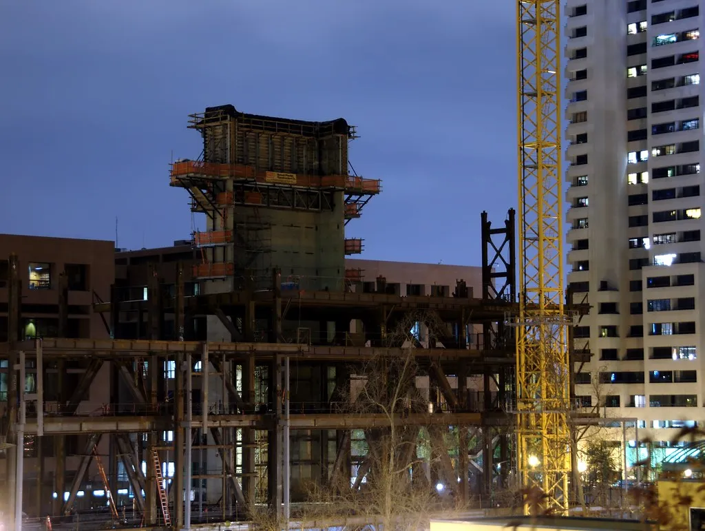 High-rise construction site at blue hour with tower crane